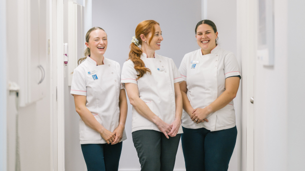 Best St. Dental | Team of Best St Dental staff standing outdoors, smiling together in uniform